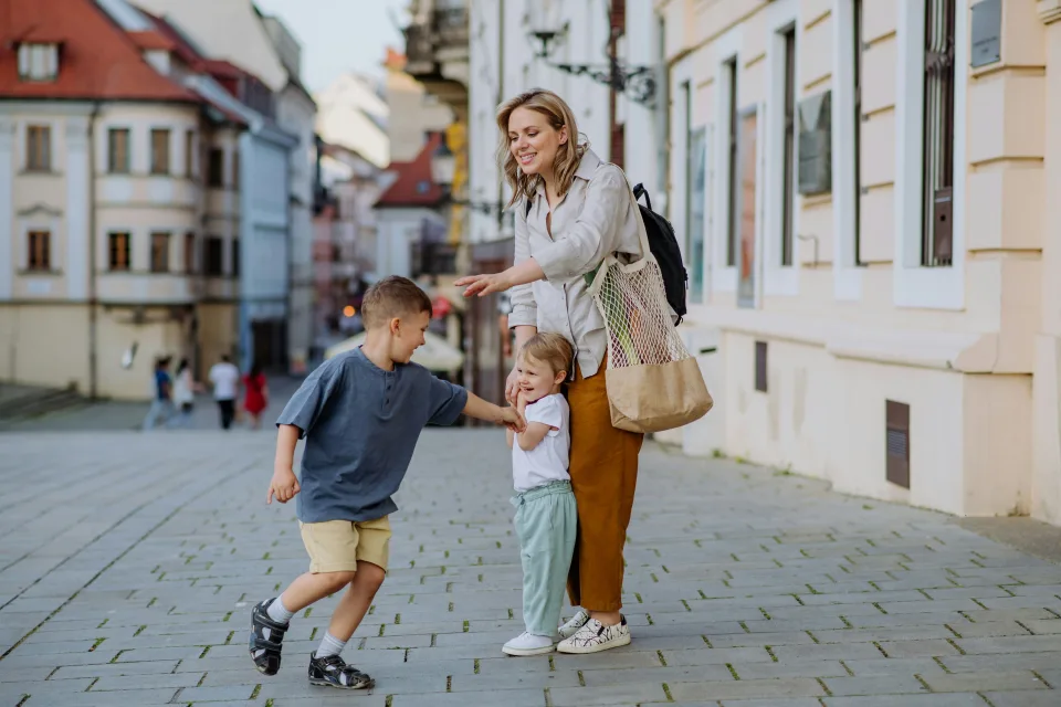 anya a két gyermekével játszik a belvárosban
